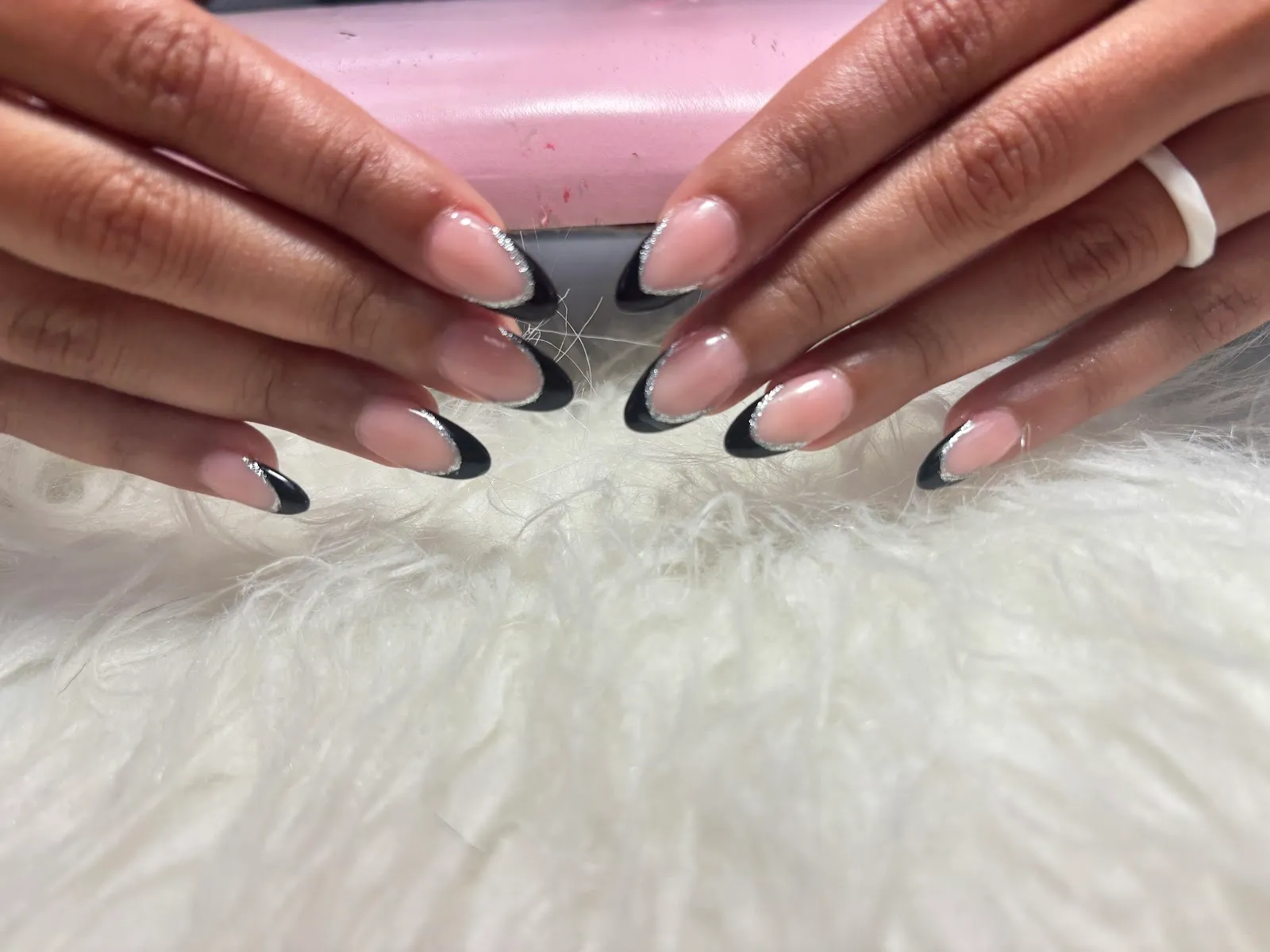 Black French-tip almond nails outlined with fine silver glitter